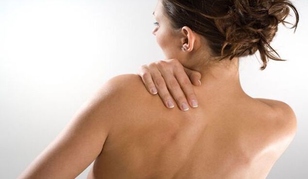 La mujer está preocupada por el dolor debajo del omóplato izquierdo en la espalda por detrás. 